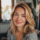 Femme souriante chez elle, ambiance chaleureuse.