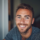Homme souriant dans un intérieur lumineux.